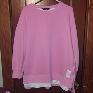 Pink Sweatshirt It features a unique split hem with functional side zippers. .